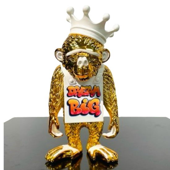 Sculpture of an golden monkey with white Dream Big sign and crown